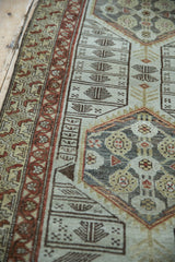 Distressed Malayer rug, floral medallion with geometric border in rust, ivory, and beige tones.