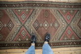 Vintage Caucasian runner with dusty aubergine field, serrated geometric patterns, pawn border.
