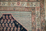 Antique Malayer rug corner with navy boteh field, stylized birds, and fuchsia, ivory border details.