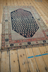 Worn corner of antique Malayer rug, with navy boteh field and ivory, fuchsia floral borders.