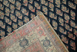 Antique Malayer rug corner showing dark navy boteh pile and woven foundation with old adhesive.