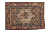 Vintage hand-knotted Senneh rug with a hexagonal medallion on a navy blue Herati field and a rust-red border.