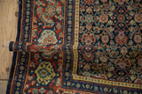 A rolled corner of a vintage Senneh rug shows the pliable texture and Samovar Turtle design border.