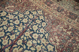 Antique Kermanshah carpet: ivory millefleur on cobalt tree of life, adjacent to aubergine scrolls.