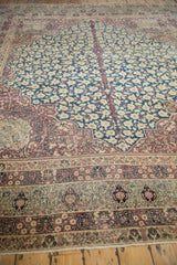Antique Kermanshah carpet's scrolling Islimi border, blossom cartouches, and millefleur field.