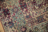 Antique Kermanshah carpet detail showing Islimi scrolling main border with aubergine and blue blossoms.