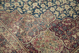Antique Kermanshah carpet with dusty aubergine scrolling Islimi border and ivory blossoms.