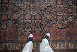 On-the-floor view of a vintage Bibikabad carpet showing the detailed Herati pattern and texture.