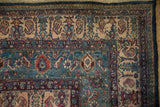 Boteh and shrub motifs in the navy, red, and ivory borders of a vintage Bibikabad carpet.