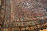 Intricate border detail of a Persian carpet with boteh motifs and notable blue abrashes.