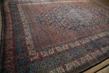 Angled perspective of a vintage Bibikabad carpet showing its navy medallion and madder red field.