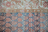 Detail of a Persian Malayer runner's boteh field and floral border showing variations in pile height.