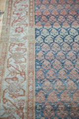 Angled view showing the low pile texture of the boteh field and meandering floral border.