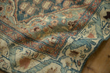 Textured pile of vintage distressed Malayer runner with dusty teal, terracotta, and beige arabesque border.
