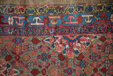 Close view of the traditional borders and dense henna field of an antique Persian Serab.