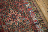 Detailed view of a camel hair Serab rug's scalloped medallions and colorful geometric border.