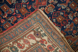 Detail of Antique Bijar rug's indigo blue pile, geometric Herati motif, and hand-knotted foundation.