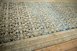 Angled view of a distressed antique Malayer carpet showing an abrashed Herati field.