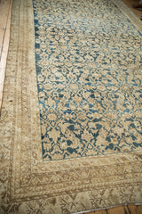 Corner detail of distressed antique Malayer carpet, showcasing intricate borders and a worn Herati pattern.