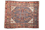 Antique Hamadan rug with a blue Herati medallion, ivory spandrels, and visible foundation wear from age.