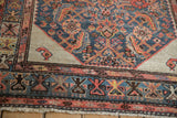Ivory corner spandrel with a singular boteh and geometric border on a hand-knotted antique Hamadan rug.