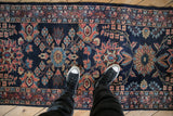 A perspective shot showing the scale and floral pattern of a vintage navy and rose Lilihan runner.