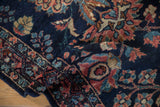 Rich texture of a vintage Lilihan rug's glossy wool pile, showing floral motifs in dusty rose and teal on a navy field.