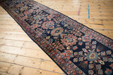 Side view of a vintage Persian Lilihan runner showing the varying tones and sheen on its navy and blush wool pile.