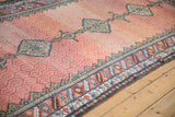 Angled close-up of the antique Hamadan rug's hexagonal lattice field and serrated leaf border.