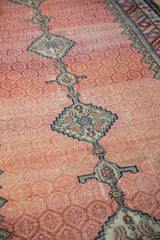 Close-up of a Samovar medallion on the ruby-red lattice field of an antique Hamadan runner.