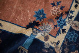 Antique Peking carpet: Cobalt blue vase, floral sprays, and ivory border on pale copper.
