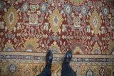 Antique Mahal carpet field with staggered floral medallions in black cherry red, dusty gold, and blue.