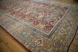 Corner of antique Mahal rug, red field with floral medallions, blue, gold, and softened rose border.