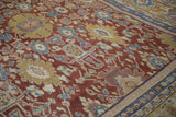 Close-up of floral medallions in gold, mauve, and sky blue on an antique Mahal carpet's cherry red field.