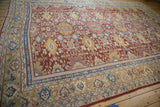 Perspective view of an antique Mahal carpet's dense floral pattern in red, gold, mauve, and blue.