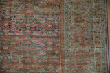 Worn, low-pile texture of an antique Fereghan carpet's Herati field and sea foam green border.
