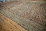 Angled view showing the heavy abrashes and distressed, low-pile texture of an antique Fereghan carpet.