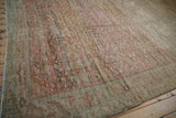 An angled view across the distressed Fereghan carpet shows its heavy color abrashes and allover pattern.