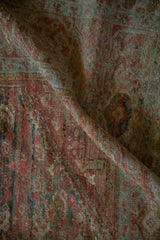 A soft fold in a distressed Fereghan carpet reveals its low, textured pile and time-softened colors.