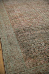 Distressed texture of a Fereghan carpet with heavy abrashes across the ruby field and sea foam border.