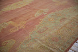 Fine weave revealing knot heads on a distressed Oushak in faded red and seafoam green.