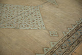 Finely-worn texture on a Malayer carpet's camel field and dusty blue geometric medallion.