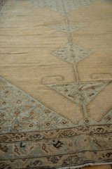 Angled view of the distressed low pile and hand-knotted texture on an antique Malayer carpet.