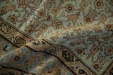 A gentle fold reveals the low, even wear of the antique Persian carpet's hand-knotted pile.