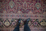 Personal view showing the scale of the antique Meshed carpet's wide border and low pile magenta field.