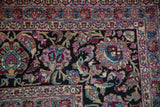Cloudband ribboned floral vines in magenta and blue on the dark navy field of an antique Persian carpet.
