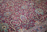 Low pile texture of an antique Meshed carpet with scrolling arabesques and lotus motifs in deep magenta.