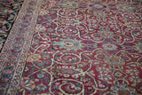 Cloudband ribboned vines and lotus flowers in the magenta field of an antique Persian carpet.