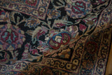 A folded view revealing the hand-knotted texture and intricate lotus motifs of the antique carpet.