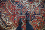 Detailed view of the stepped medallion and serrated leaves on a vintage Persian Heriz carpet.